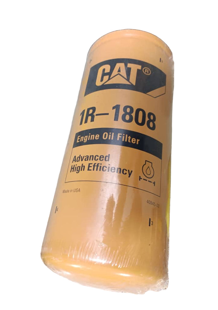 Yellow oil filter with 'CAT' branding on a concrete floor.